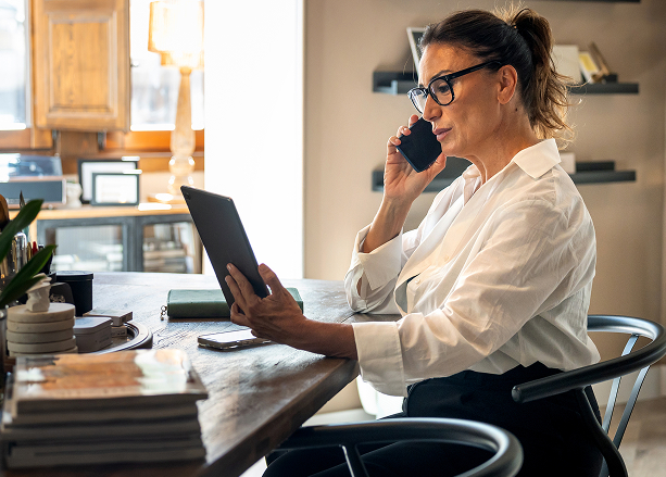 Legal receptionist on a phone call reviewing new client intake details on a tablet